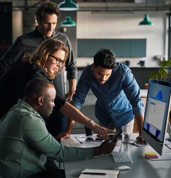 Certified MSP IT professional collaborating with clients at a computer to deliver tailored technology solutions for businesses