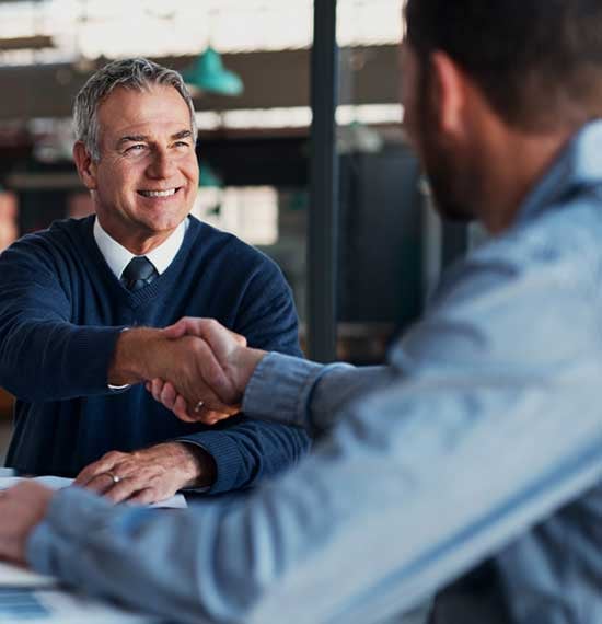 Business owner shaking hands with an IT expert after partnering for a holistic and secure IT infrastructure solution
