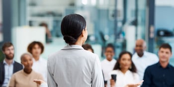 Hero image for blog post How Can SMBs Improve Cybersecurity Transparency Effectively. The image has the head of a company practicing cybersecurity transparency by informing employees about the lates cybersecurity policies. 
