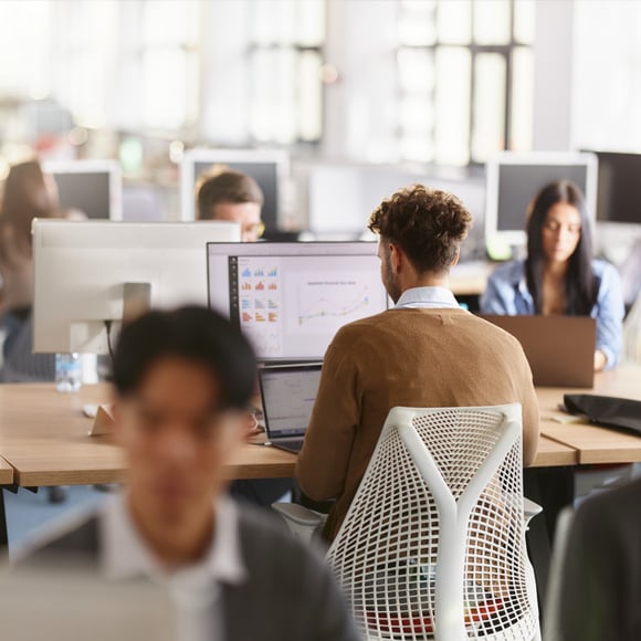 Image of an office with staff working on secured computers.