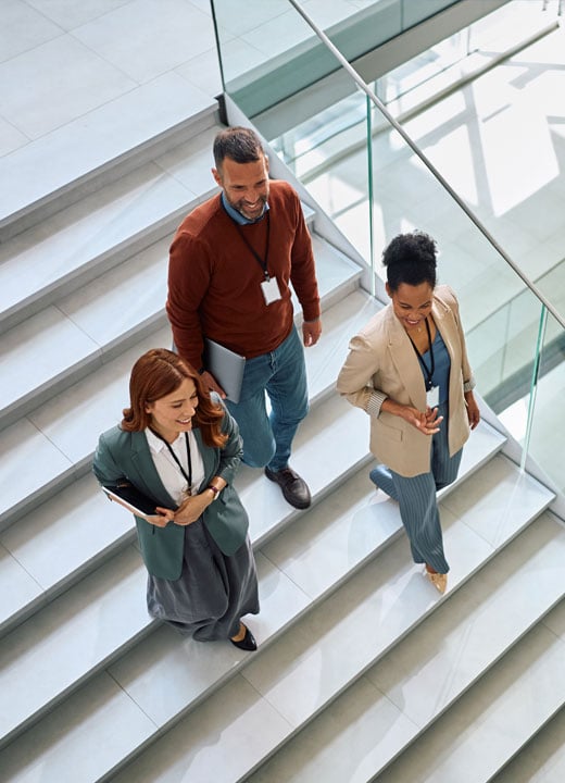Image of happy employees walking down the stairs in the office.